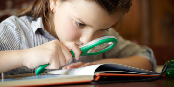 small-girl-reading-with-magnifying-glass