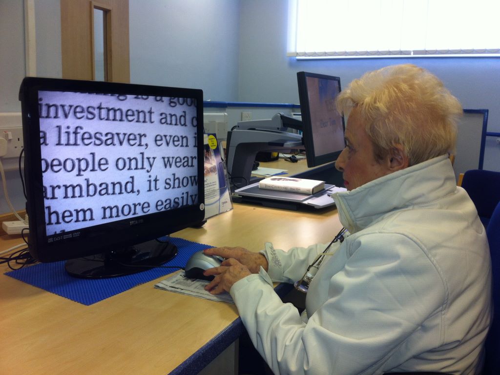 A woman looking at a screen on which words from a book have been magnified.