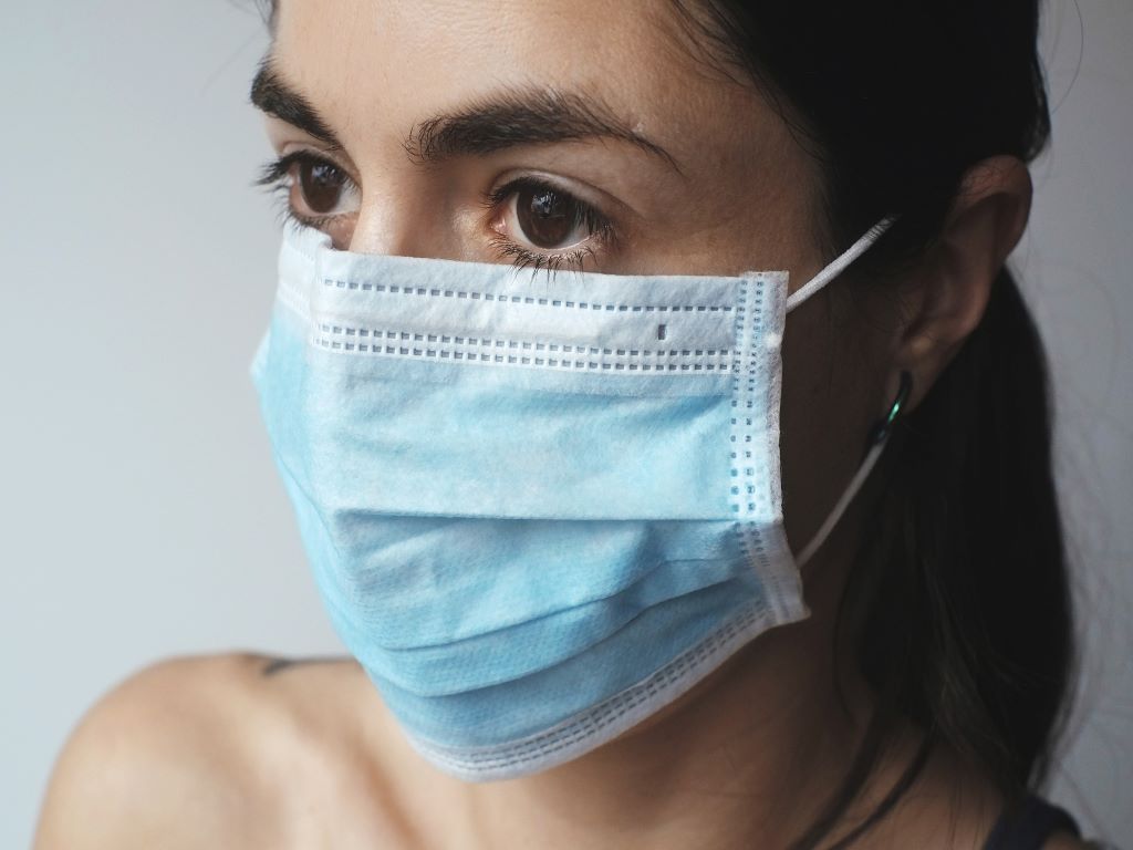 A close of a woman's face wearing a mask.