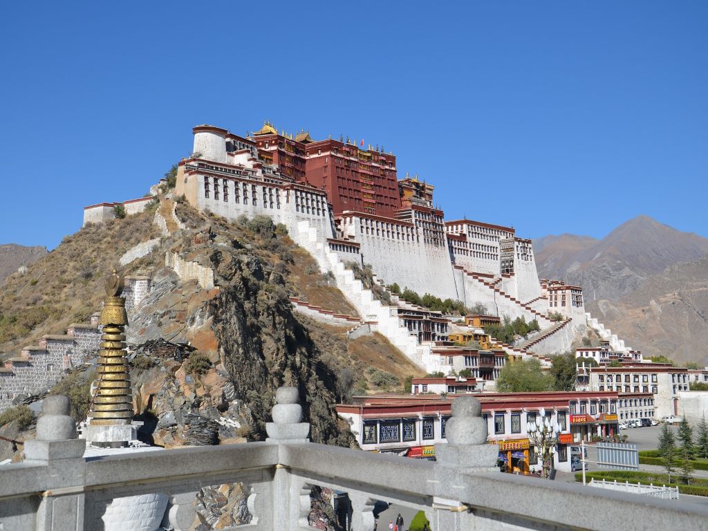 A tibetan monastry building on top of a mountain.