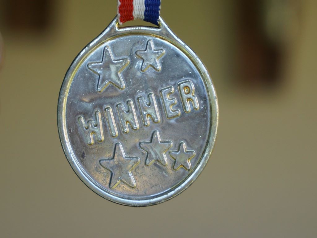 A silver medal with the word winner.