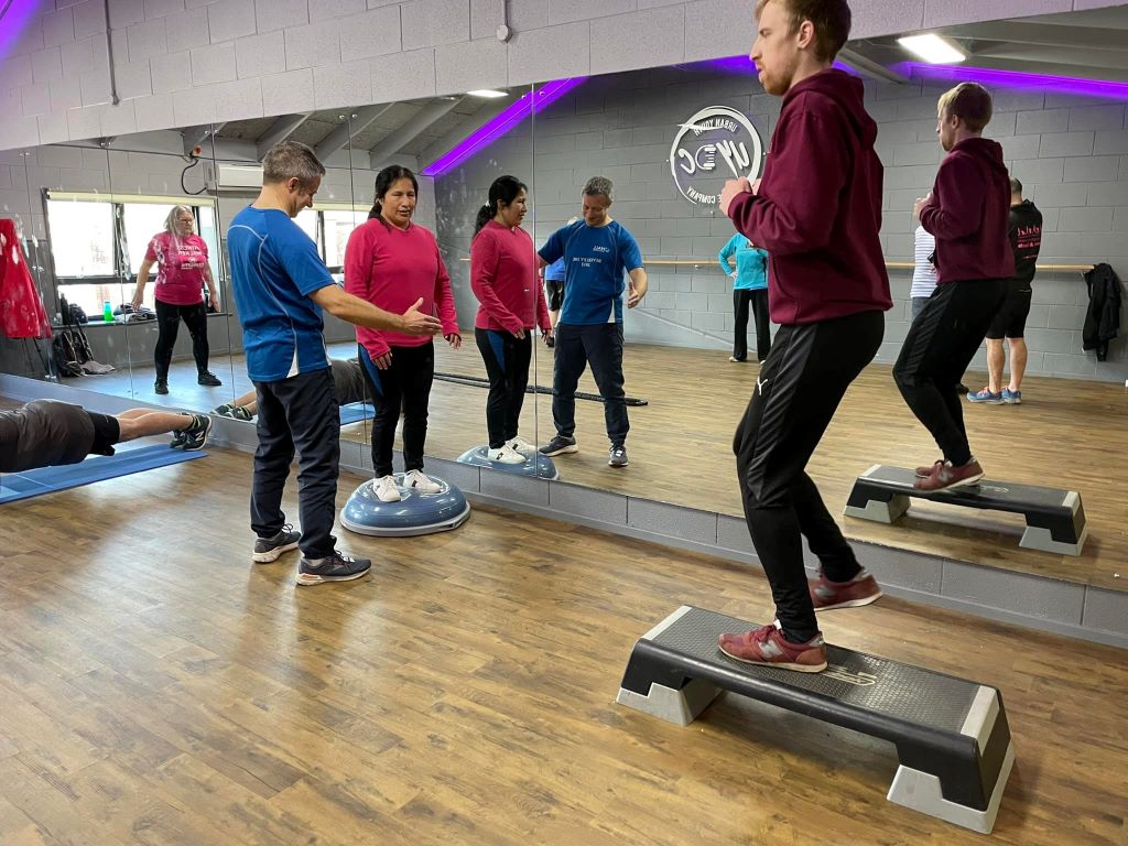 A group of people undertainign exercises in a gym.
