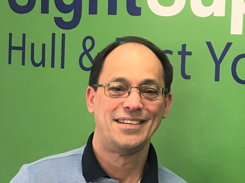 a smiling man wearing spectacles.