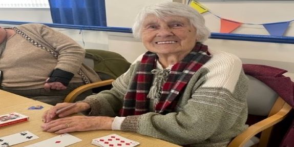 A smiling lady playing cards