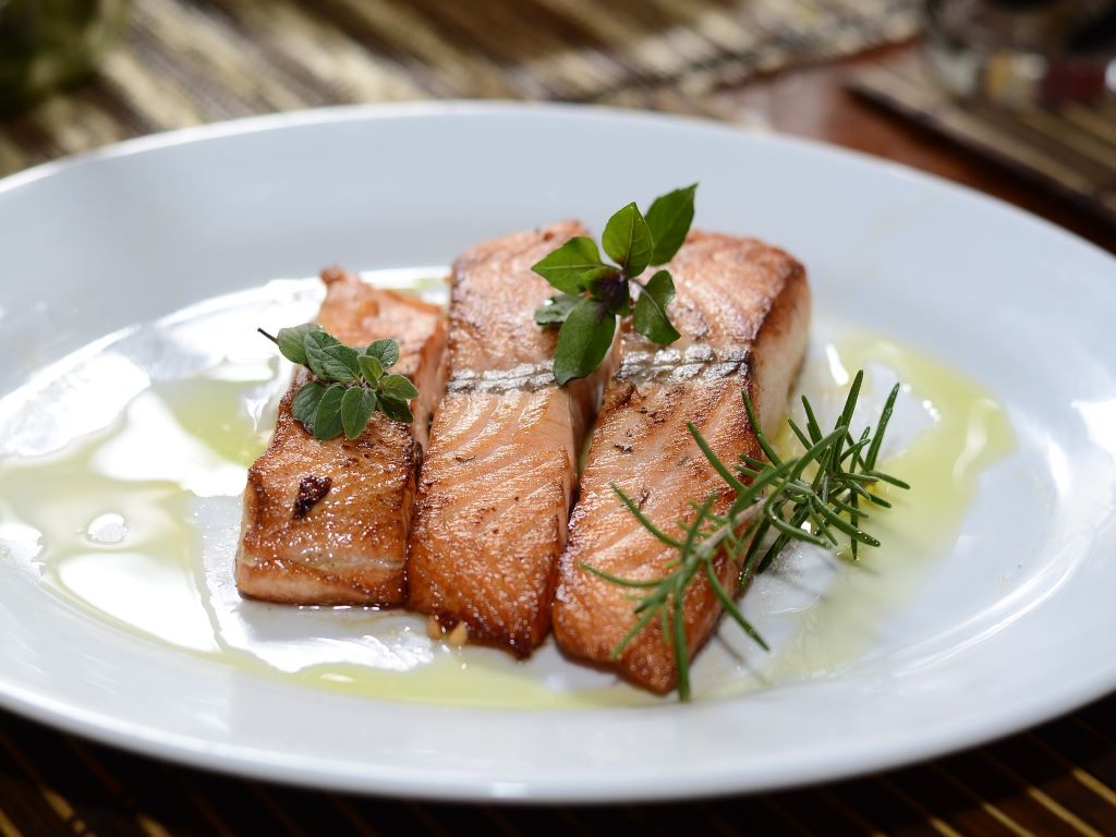 Three cooked salmon fillets on a plate