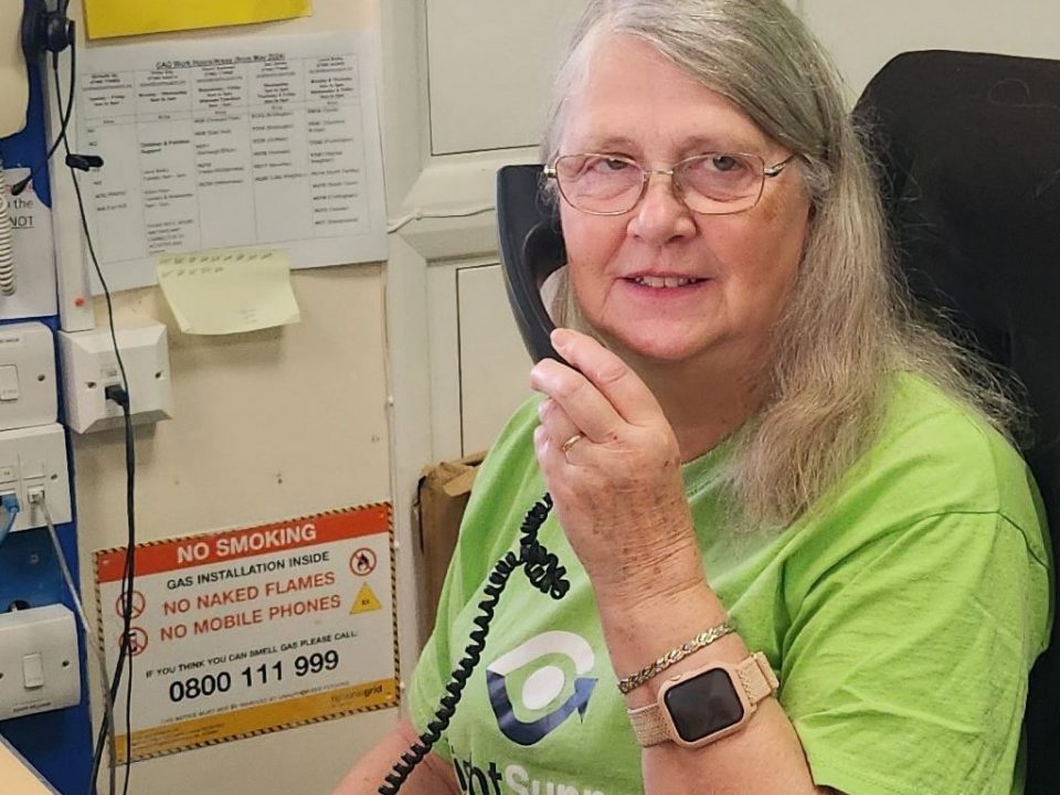A smiling lady on the telephone.