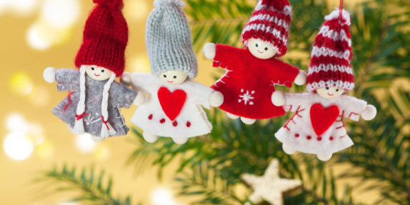 A series of handmade ornaments hanging on a Christmas tree